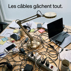 Bureau encombré de câbles avec lampe filaire classique illustrant le problème résolu par la lampe sans fil MycoLamp