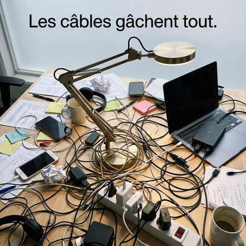 Bureau encombré de câbles avec lampe filaire classique illustrant le problème résolu par la lampe sans fil MycoLamp